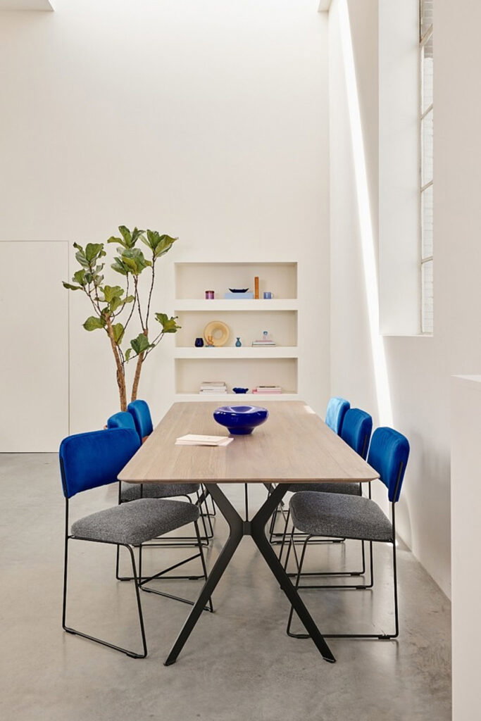 blauwe eetkamerstoelen aan een rechthoekige tafel in interieursetting