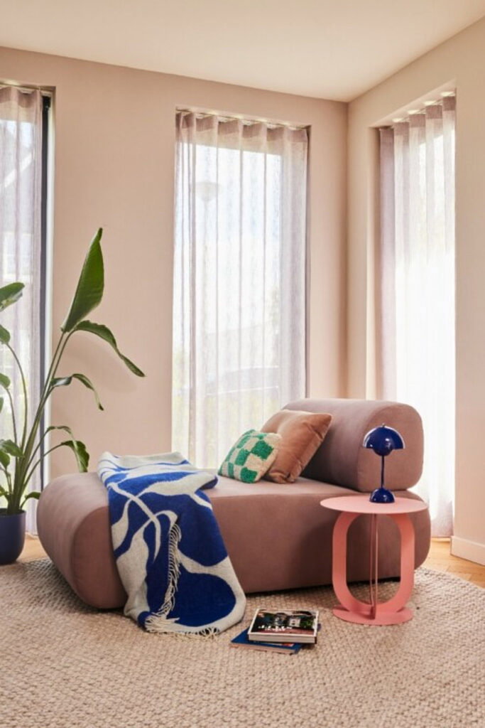 grote lounge fauteuil in roze bij het raam