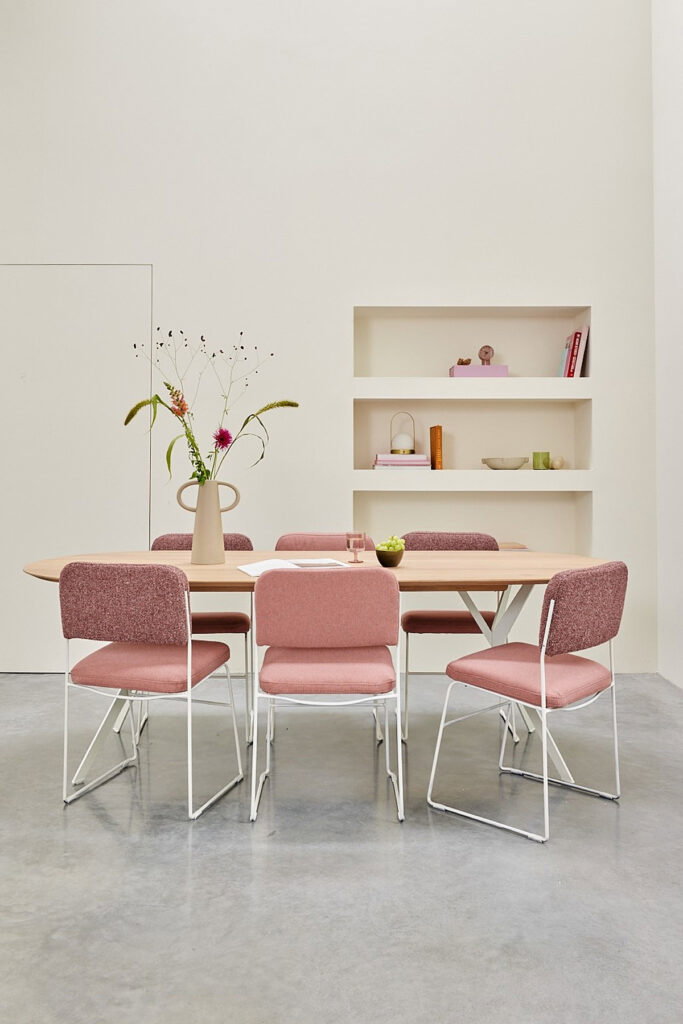 roze eetkamerstoelen aan ovale eettafel van het merk Noga Design